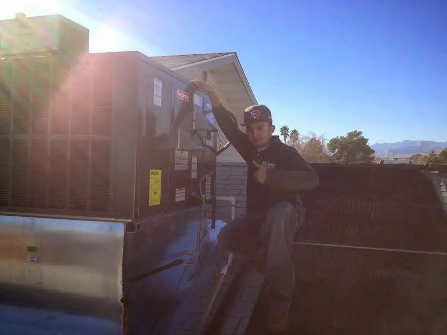 HVAC technician performing Air Duct Cleaning on a rooftop unit in Truckee